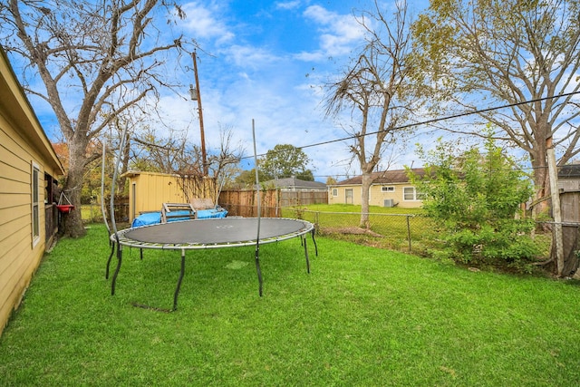 view of yard featuring a storage unit and a trampoline