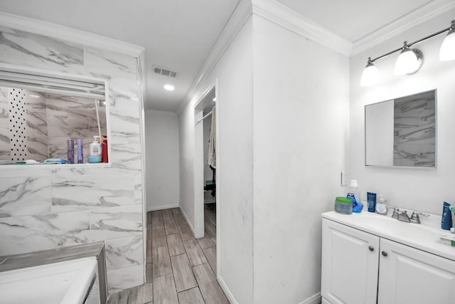 bathroom with vanity, a bath, and ornamental molding