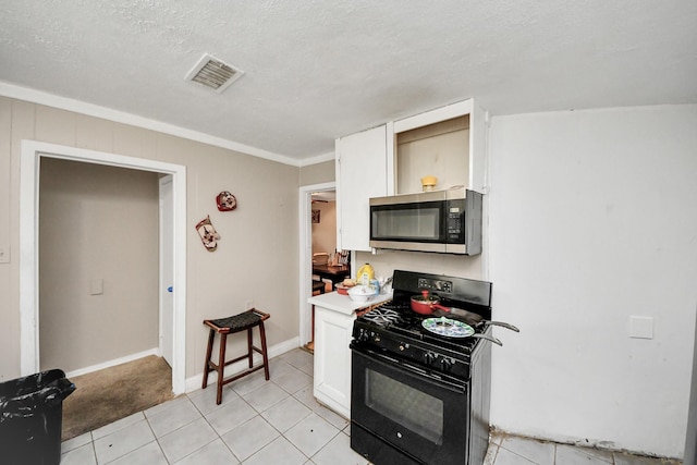 kitchen featuring a textured ceiling, crown molding, light tile patterned floors, white cabinets, and black gas stove