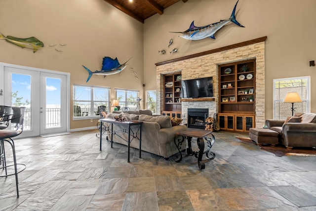 living room featuring built in shelves, a towering ceiling, wooden ceiling, and beam ceiling