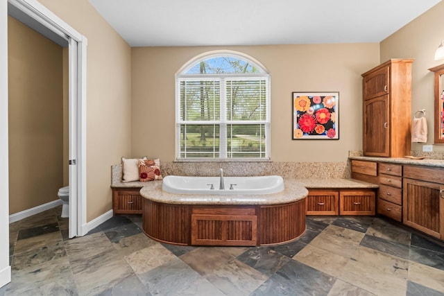 bathroom featuring a bathing tub, vanity, and toilet