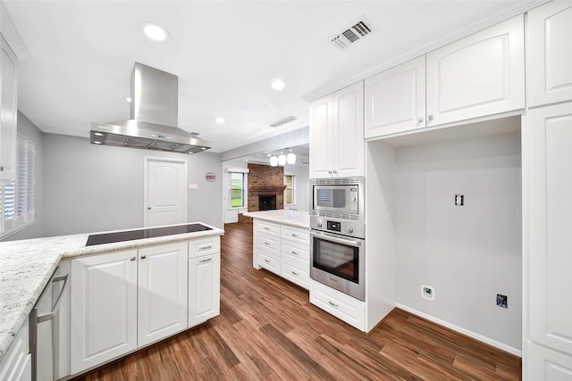 kitchen with white cabinetry, appliances with stainless steel finishes, dark hardwood / wood-style flooring, pendant lighting, and island exhaust hood