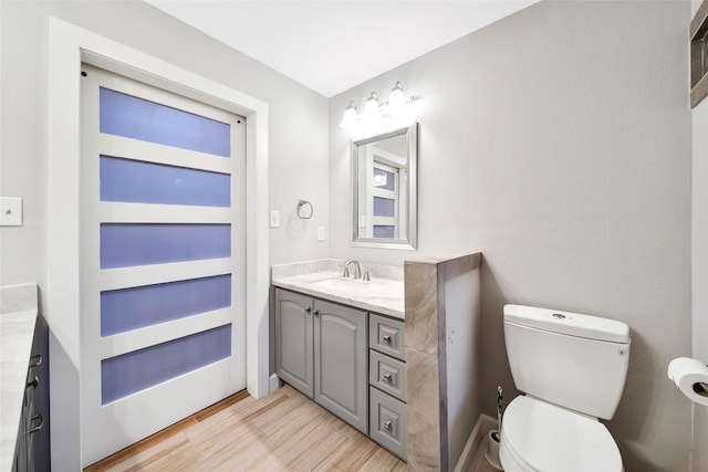 bathroom featuring vanity, hardwood / wood-style floors, and toilet