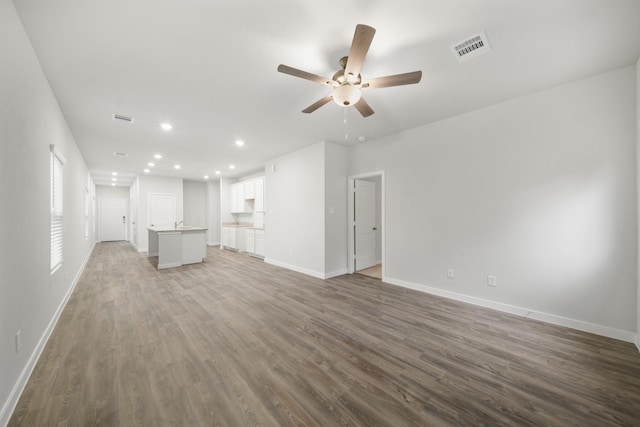 unfurnished living room featuring hardwood / wood-style flooring and ceiling fan