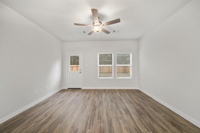 unfurnished room with a wealth of natural light, dark hardwood / wood-style floors, and ceiling fan