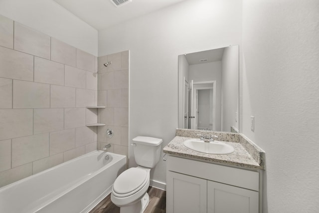 full bathroom featuring vanity, hardwood / wood-style floors, toilet, and tiled shower / bath