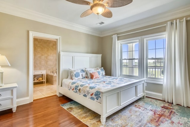 bedroom featuring ceiling fan, light hardwood / wood-style flooring, ensuite bathroom, and ornamental molding