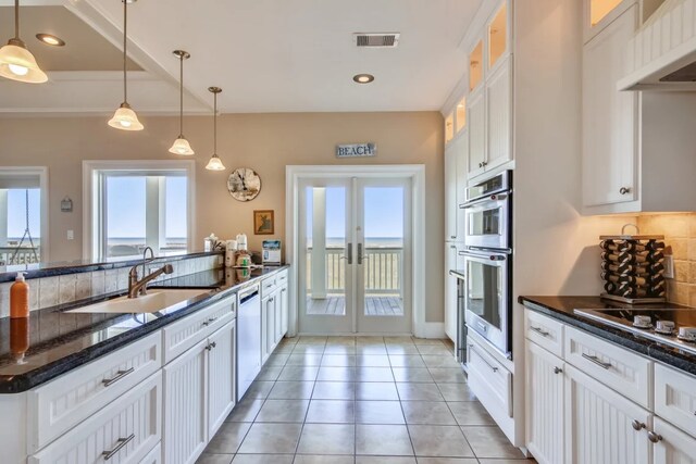 kitchen with french doors, stainless steel double oven, white cabinetry, and sink