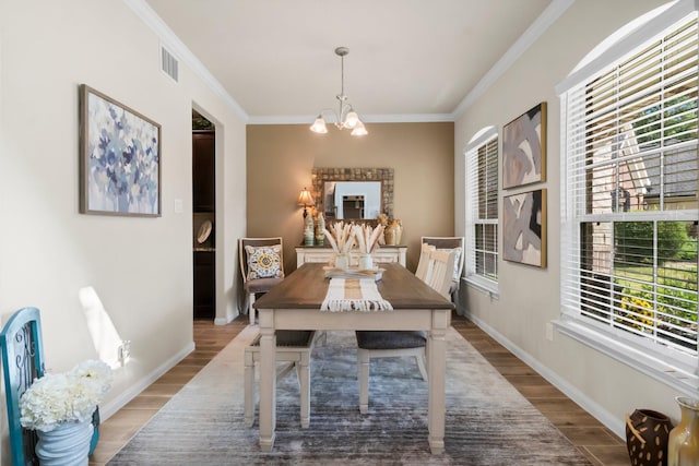 dining room with a chandelier, plenty of natural light, and wood-type flooring