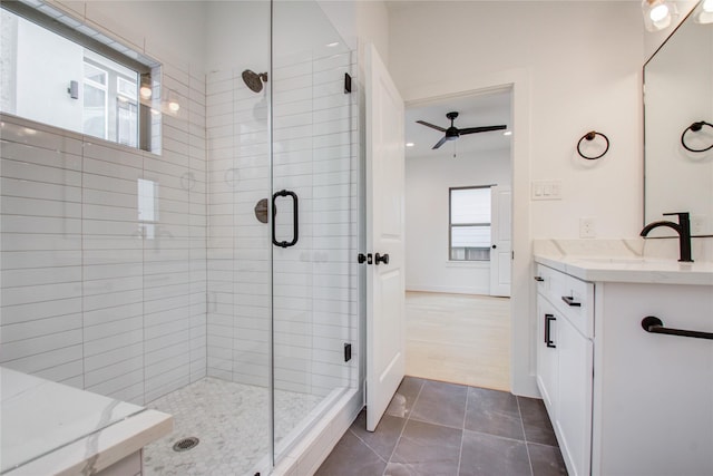 bathroom with walk in shower, plenty of natural light, vanity, and tile patterned flooring