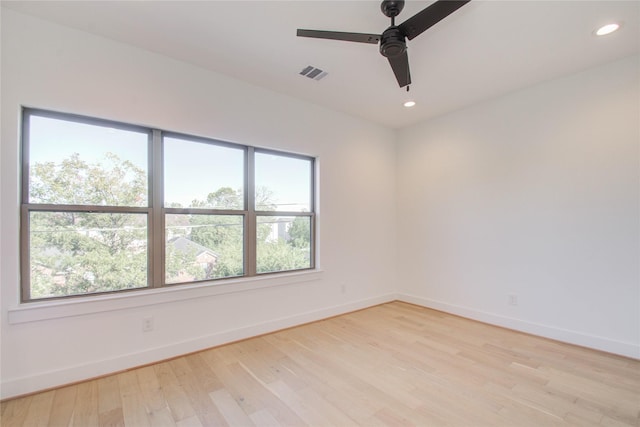 empty room featuring ceiling fan, a wealth of natural light, and light hardwood / wood-style flooring