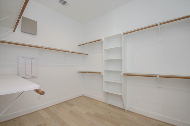 walk in closet with light hardwood / wood-style floors