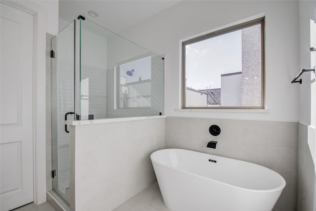 bathroom featuring plus walk in shower and tile walls