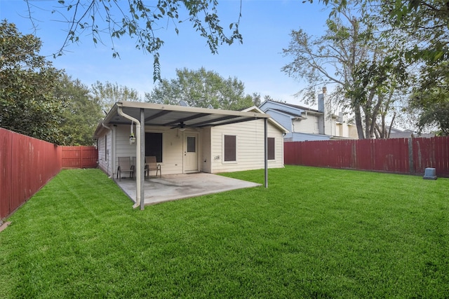 back of house featuring a lawn, ceiling fan, and a patio area