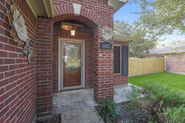 view of exterior entry with a lawn