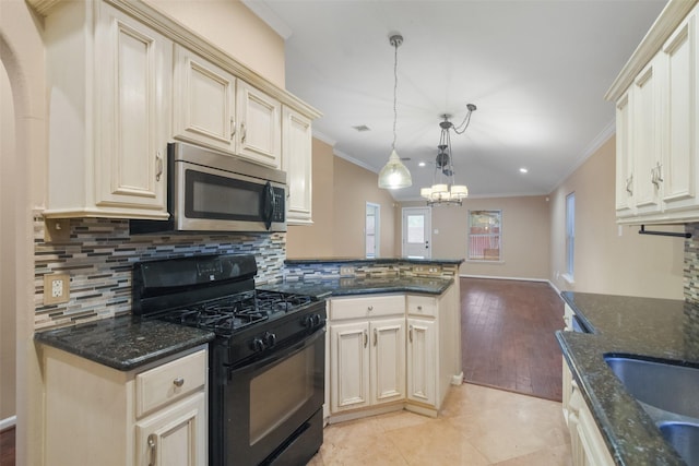 kitchen featuring black gas range, dark stone countertops, crown molding, and decorative light fixtures