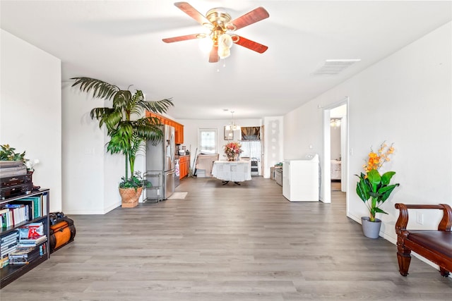 interior space with light wood-type flooring, washer / clothes dryer, and an inviting chandelier