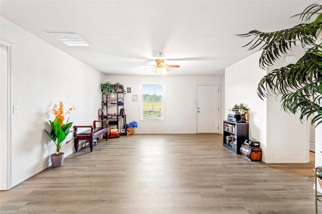 living area featuring ceiling fan and light hardwood / wood-style floors