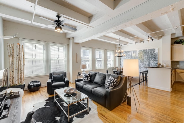 living room featuring light wood-type flooring, beam ceiling, ceiling fan with notable chandelier, and rail lighting