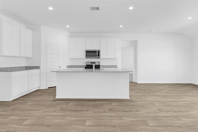 kitchen featuring a center island with sink, white cabinets, and stainless steel appliances