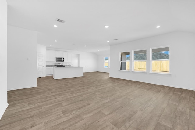 unfurnished living room with a wealth of natural light and light hardwood / wood-style floors