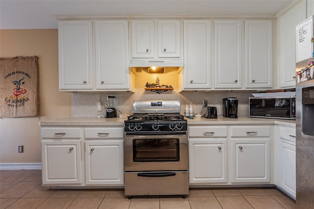 kitchen featuring light tile patterned floors, stainless steel appliances, and white cabinetry