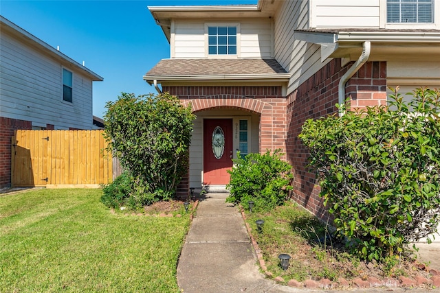 entrance to property with a lawn