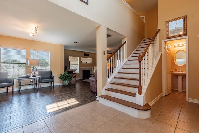 staircase featuring tile patterned floors and sink