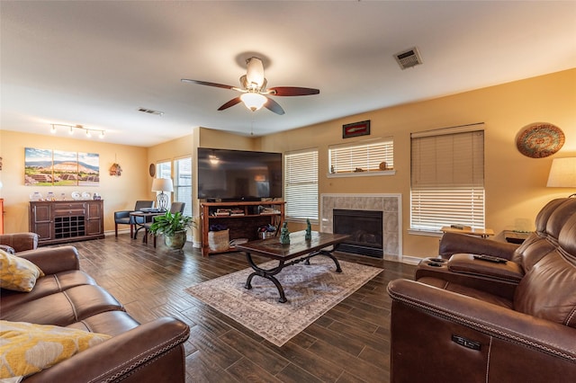 living room featuring rail lighting, ceiling fan, and a fireplace