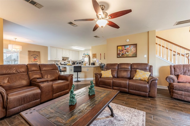 living room with ceiling fan with notable chandelier