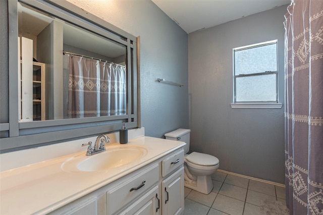 bathroom with toilet, vanity, and tile patterned floors