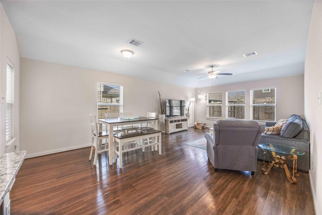 living room featuring visible vents, baseboards, wood finished floors, and a ceiling fan