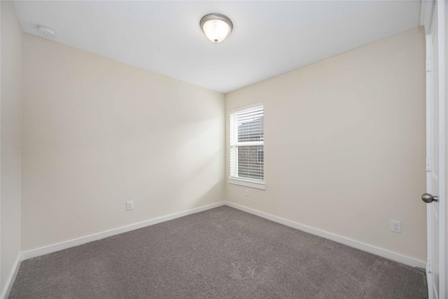 unfurnished room featuring dark carpet