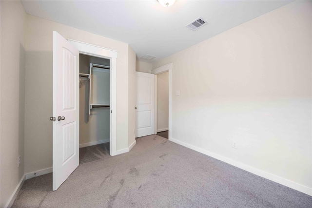 unfurnished bedroom with a closet and light carpet