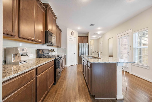 9211 Melmack Dr, Rosharon, TX 77583 - kitchen with black appliances, a sink, dark wood-style flooring, backsplash, and recessed lighting