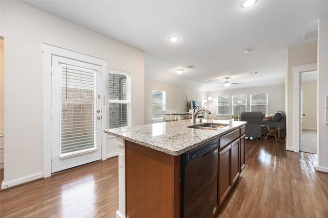 kitchen featuring ceiling fan, dishwasher, a center island with sink, sink, and dark wood-type flooring