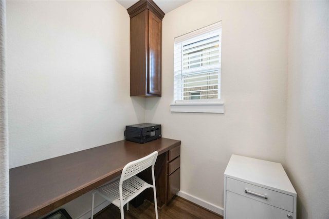 home office featuring dark wood-style floors, built in desk, and baseboards