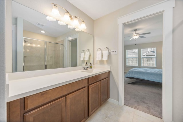 bathroom featuring a shower with shower door, vanity, tile patterned flooring, and ceiling fan