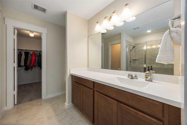 9211 Melmack Dr, Rosharon, TX 77583 - bathroom with a stall shower, tile patterned floors, a walk in closet, vanity, and baseboards