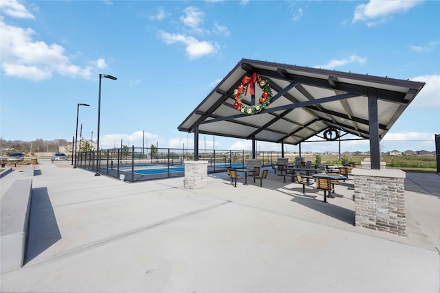 view of home's community featuring a gazebo, a tennis court, and fence