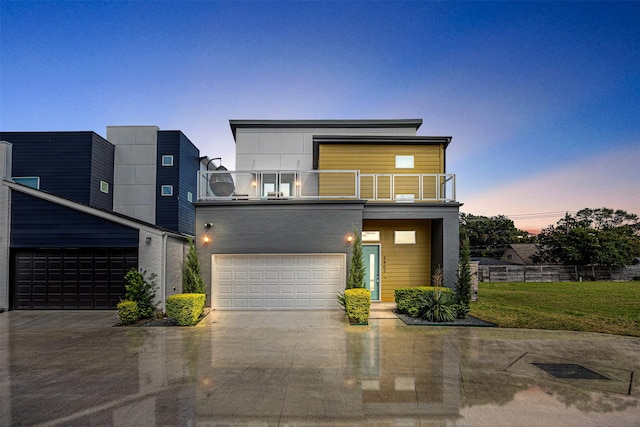 contemporary house with a yard, a balcony, and a garage