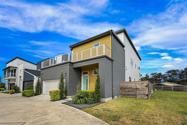 contemporary house with a balcony, a front lawn, and a garage