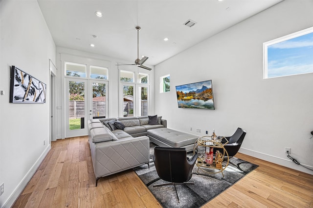 living room featuring ceiling fan, hardwood / wood-style floors, and french doors