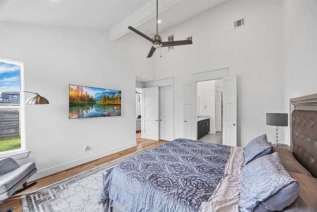 bedroom with high vaulted ceiling, ensuite bathroom, ceiling fan, beamed ceiling, and light hardwood / wood-style floors