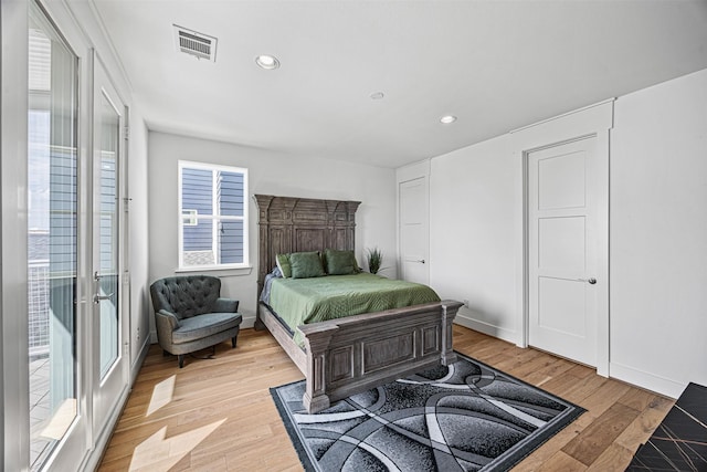 bedroom with multiple windows and light hardwood / wood-style flooring