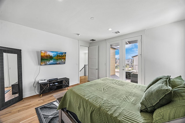 bedroom with access to exterior, light wood-type flooring, and french doors