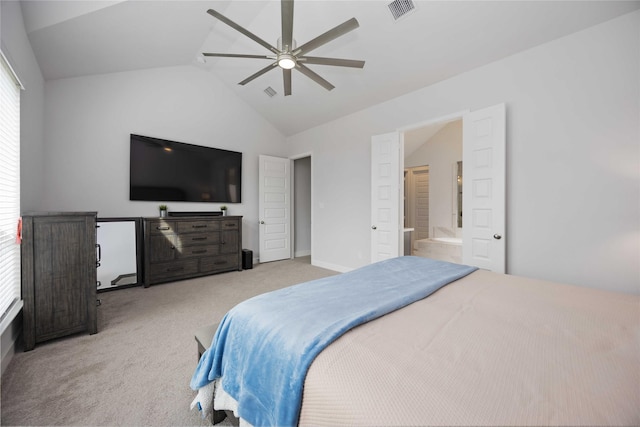 bedroom with ceiling fan, vaulted ceiling, light carpet, and connected bathroom