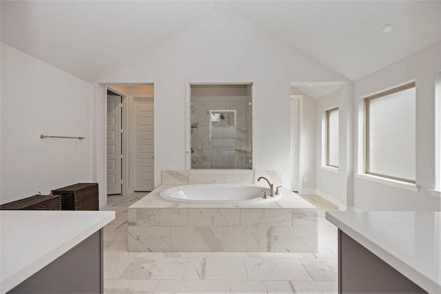 bathroom with shower with separate bathtub, vanity, and vaulted ceiling