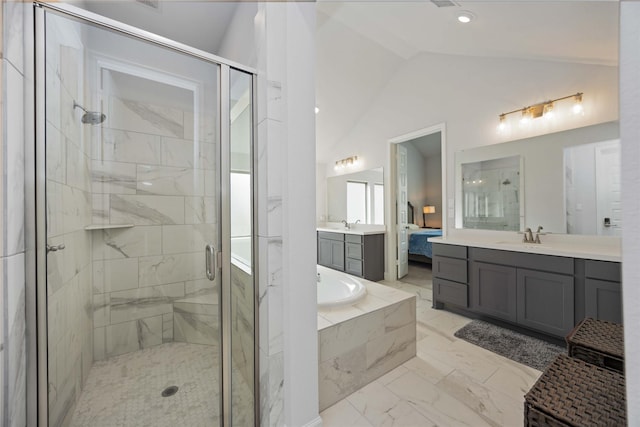 bathroom featuring vaulted ceiling, independent shower and bath, and vanity