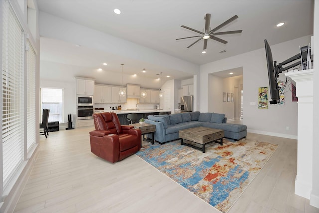 living room with ceiling fan and light hardwood / wood-style floors